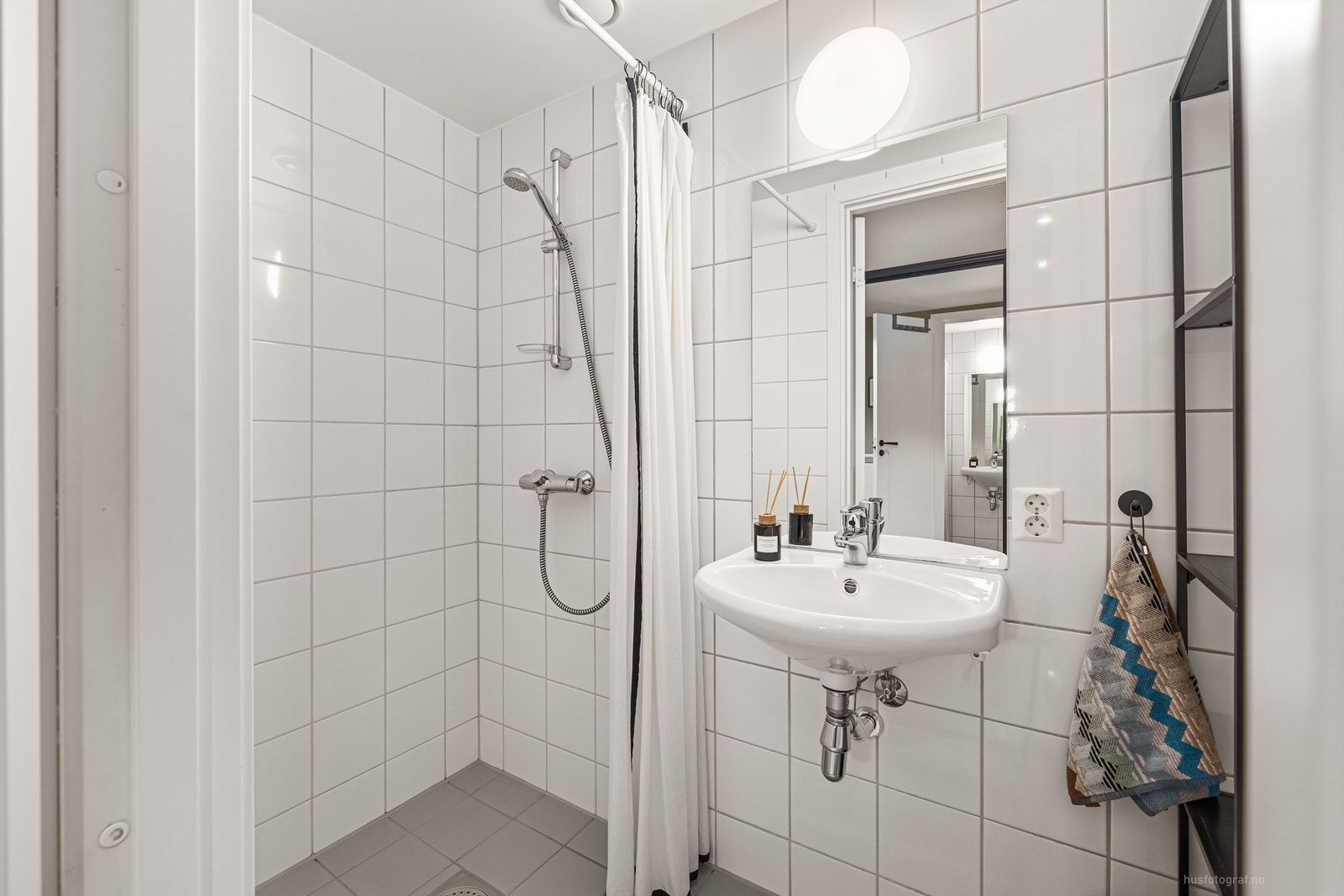 Flislagt bad 1 med dusj i hjørne som har opplegg for dusjforheng Galleribilde