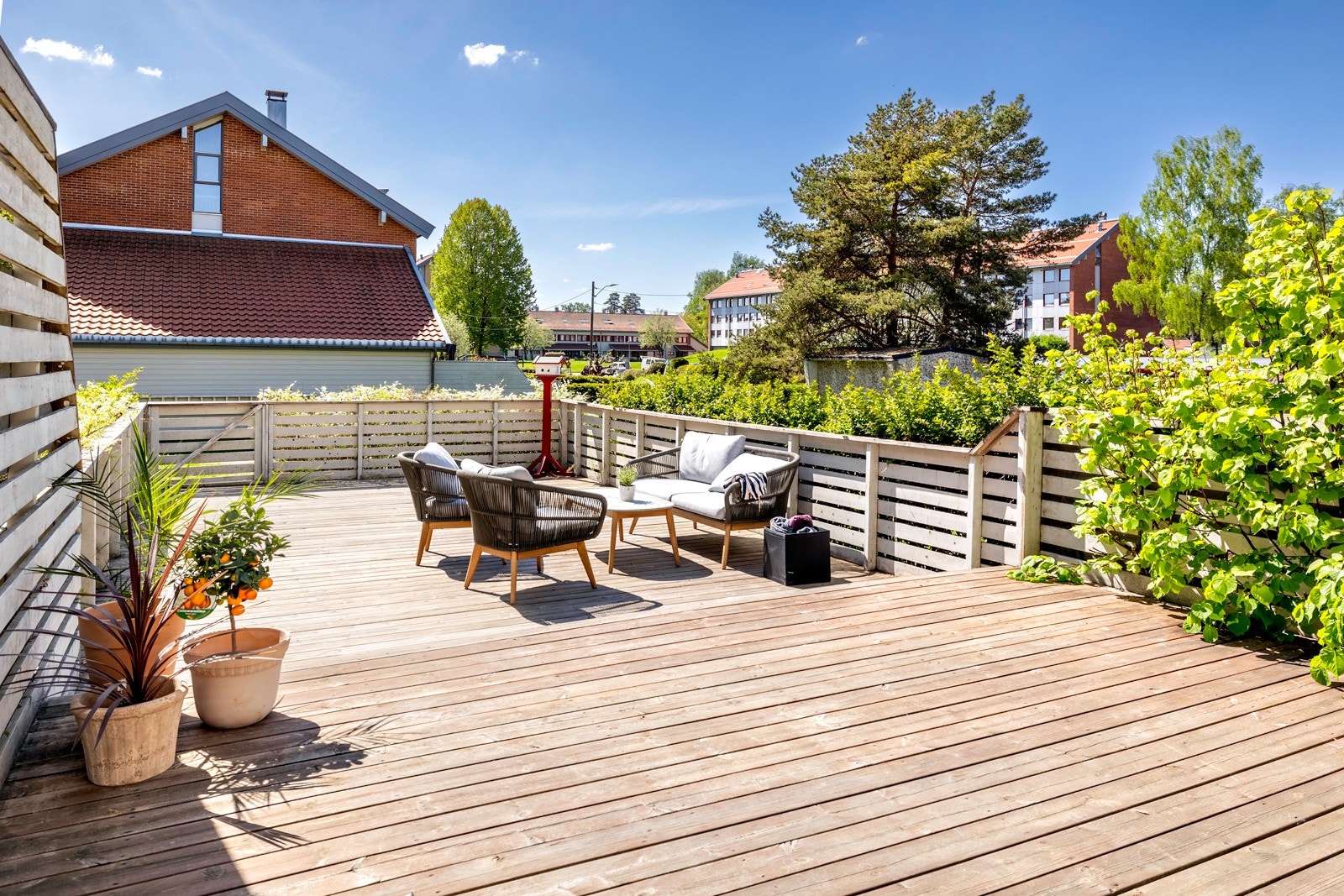 Terrassen har impregnerte terrassebord, trerekkverk og en port nederst på terrassen som gir adkomst ut til grønt fellesareal. Galleribilde