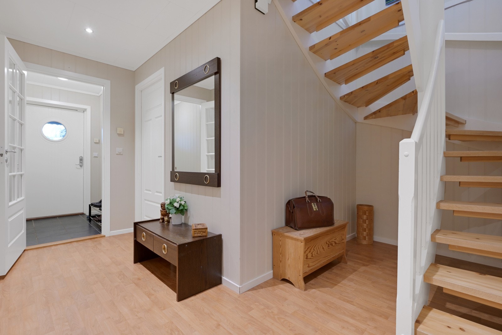 Romslig gang og hall med god plass til å sette fra seg sko og henge opp yttertøy Galleribilde