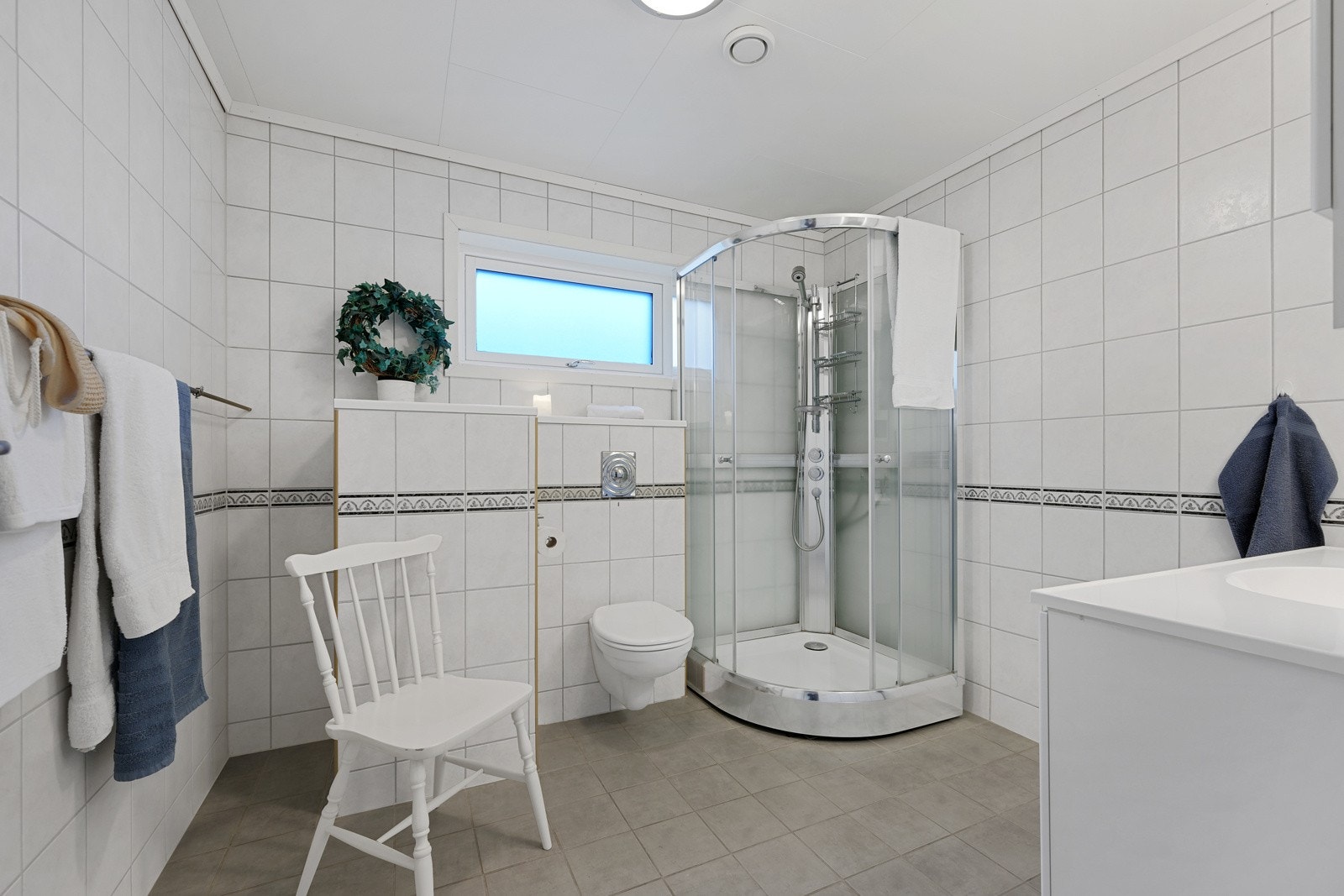 Badet inneholder servant med baderomsinnredning, vegghengt wc og dusjkabinett Galleribilde