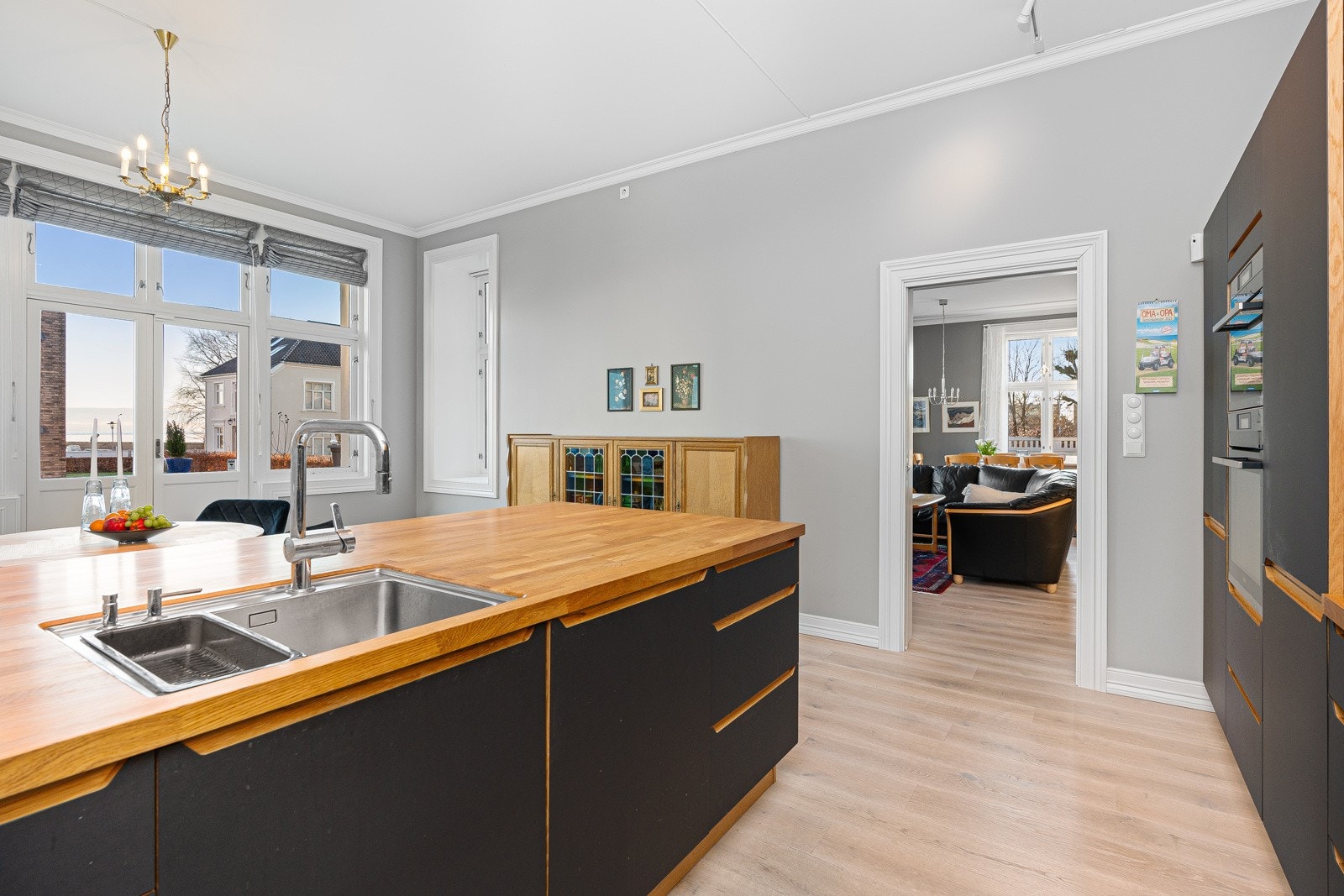 Kjøkken med kjøkkenøy og skyvedør inn til stuen Galleribilde