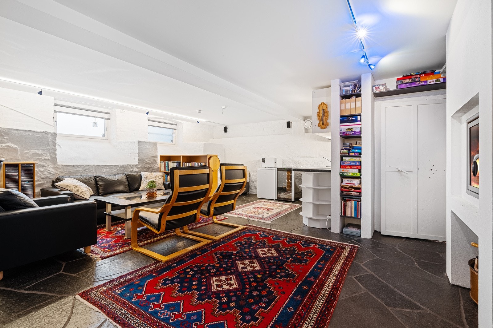 Kjellerstue med kjøkkenkrok og murt rettveggspeis Galleribilde