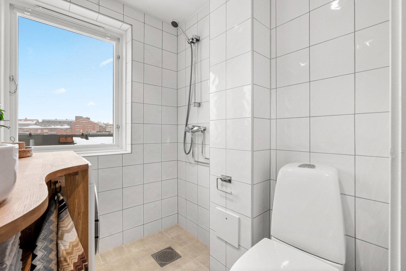 Ny, flott plasstilpasset baderomsinnredning med heltre benkeplate. Ovenpåliggende servant med ettgreps blandebatteri. Nisje for vaskemaskin som forøvrig medfølger. Dusjhjørne (med forheng). Galleribilde