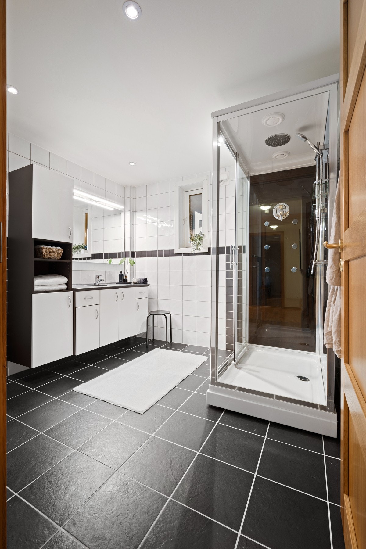 Romslig servantinnredning med god plass til håndklær og toalettartikler Galleribilde