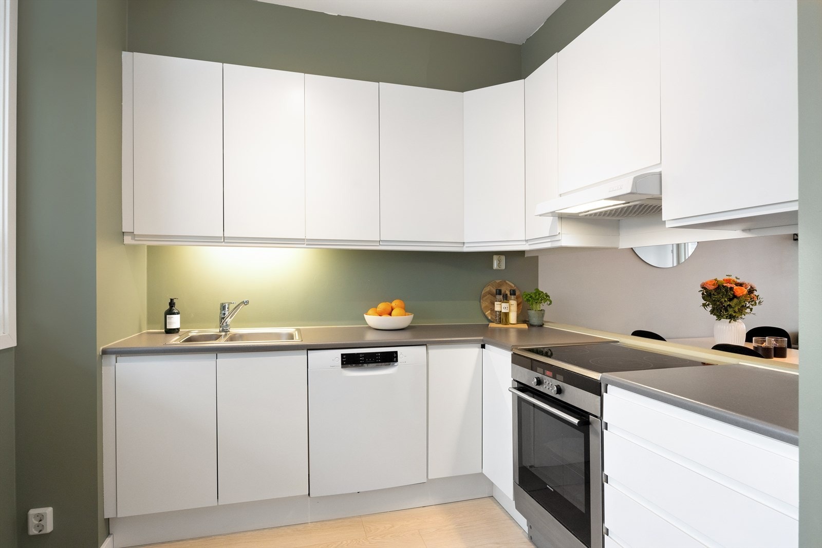 Det er malt mellom benkeplate og overskap for et stilrent uttrykk. Benkeplaten er i laminat, og oppvaskkummen er nedfelt med et ettgreps, svingbart blandingsbatteri. Galleribilde