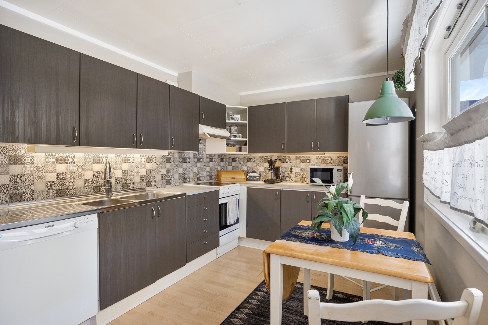 Fint vinkelformet kjøkken med god skap- og benkeplass. Galleribilde