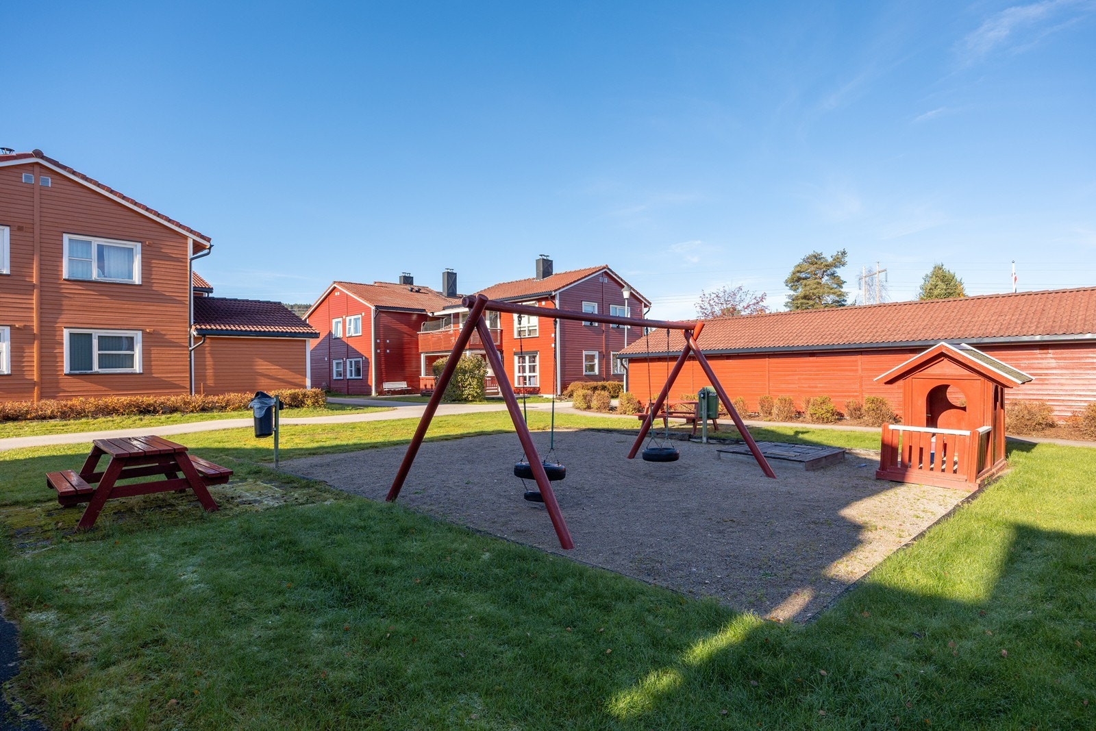 Fellesområde som er pent opparbeidet med lekeplass, plenareal og sittegrupper. Galleribilde