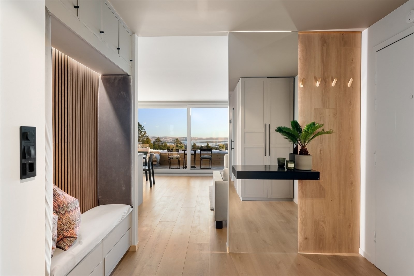 Praktisk felt i entreen med sittebenk, skuffer under, hyller over og polstret benk og sidefelt. Galleribilde