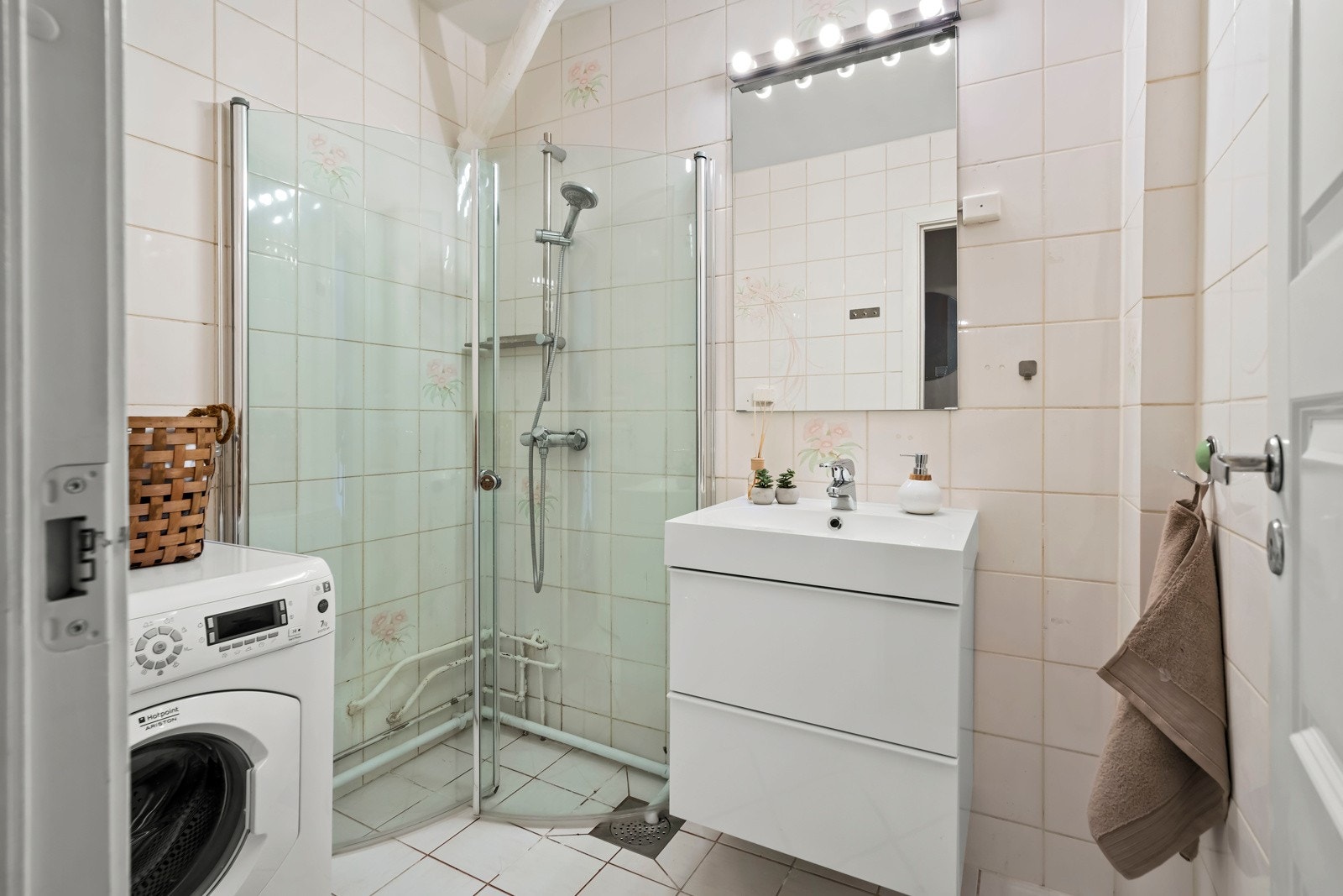 Bad med flis på vegg og gulv, malte plater i taket, dusjhjørne og opplegg for vaskemaskin. Galleribilde