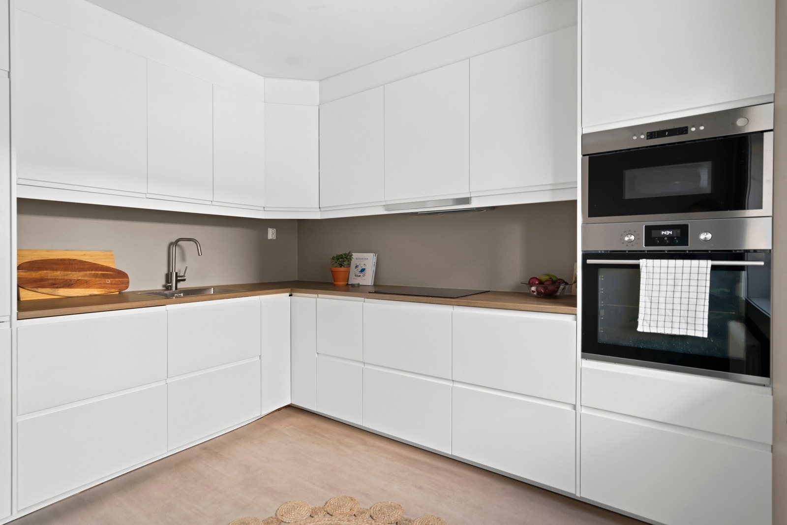 Kjøkkenløsning med glatte fronter, laminat benkeplate, godt med skap/benkeplass og integrerte hvitevarer Galleribilde