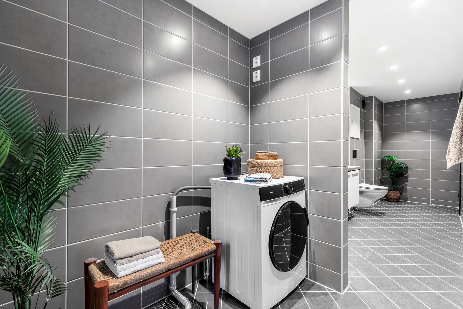 Bak dusjhjørnet har du vaskesonen med opplegg for vaskemaskin, tørketrommel og lagringsplass Galleribilde