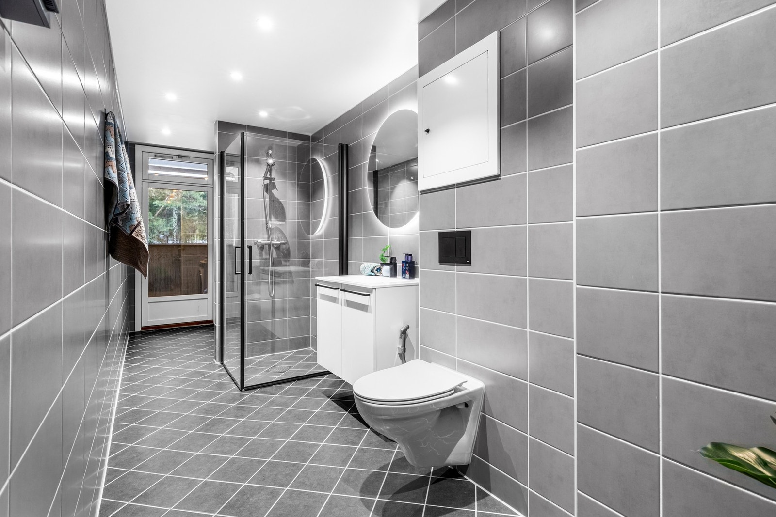 Vi beveger oss videre til bad og vaskerom som er av meget romslig karakter og med stilrent flisvalg! Galleribilde