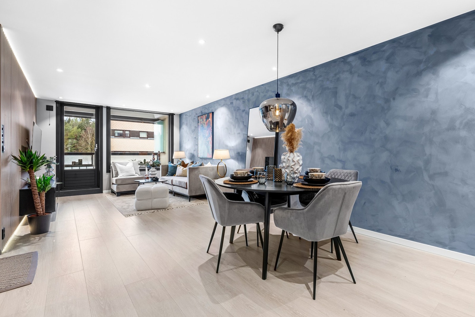 Stuen kan enkelt deles opp i soner med spisebord ved kjøkken og større sofagrupper ut mot balkong Galleribilde