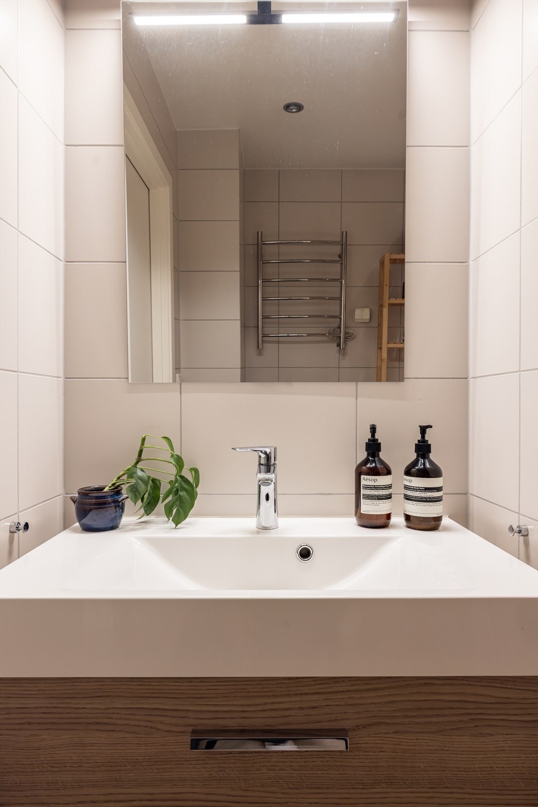 Innredningen består av servant med skuffeseksjoner, speil, dusj-nisje, toalett og elektrisk håndkletørker. Galleribilde