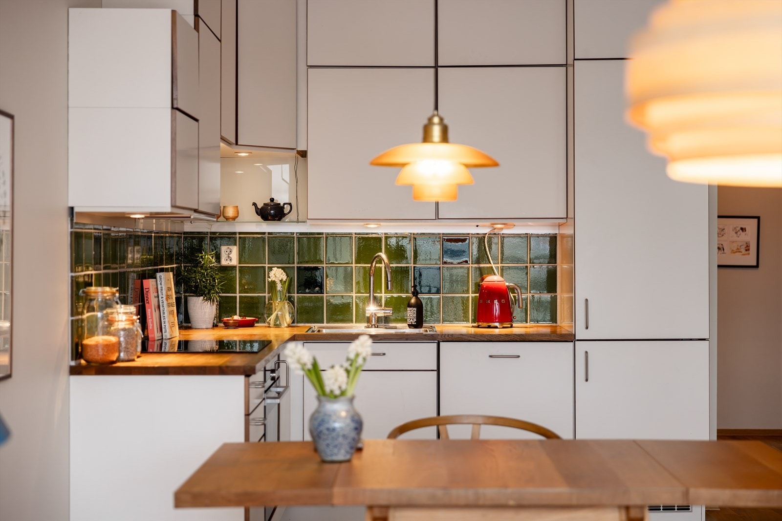 Et stilfullt kjøkken med glatte fronter, heltre benkeplate og nedfelt stålvask med ettgrepsblandebatteri. Galleribilde