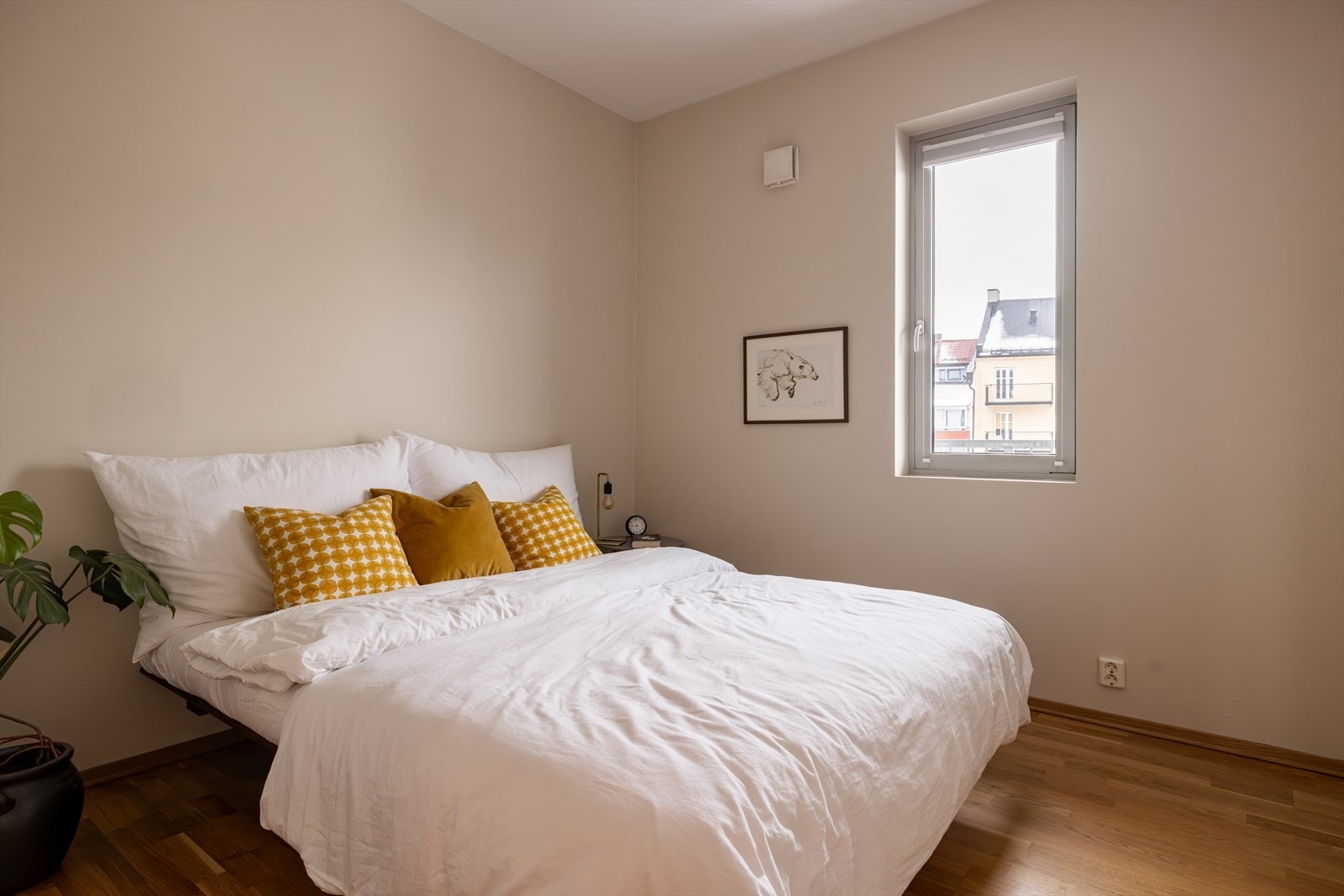 Lyst og trivelig soverom med rolige fargetoner og naturlig lysinnslipp. Galleribilde