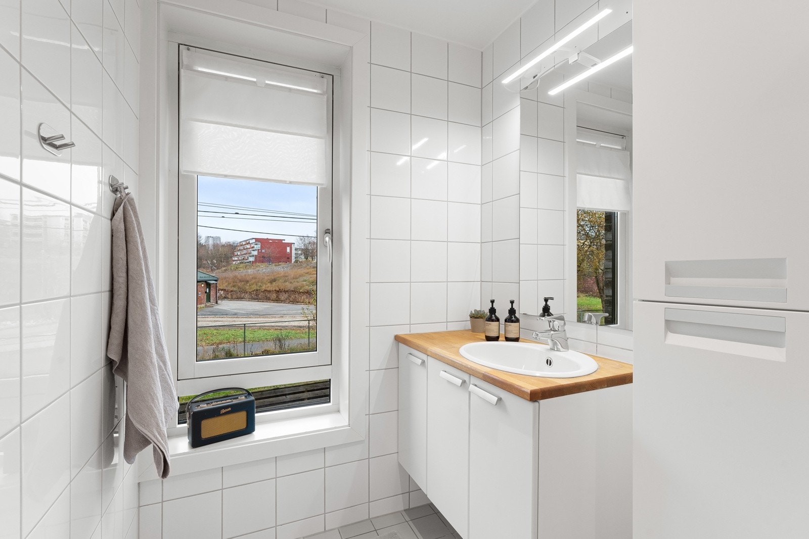 Lys og pent bad med flislagte vegger og gulv med varmekabler. Galleribilde