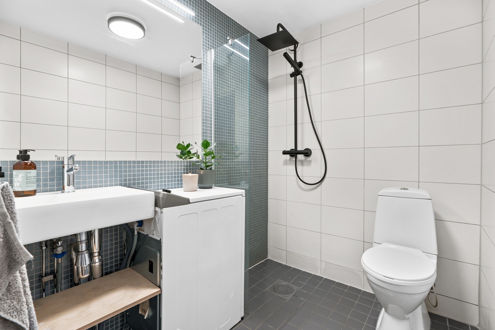 Badet er innredet med dusjhjørne med forheng (nytt blandebatteri), toalett, servant og opplegg for vaskemaskin. Galleribilde