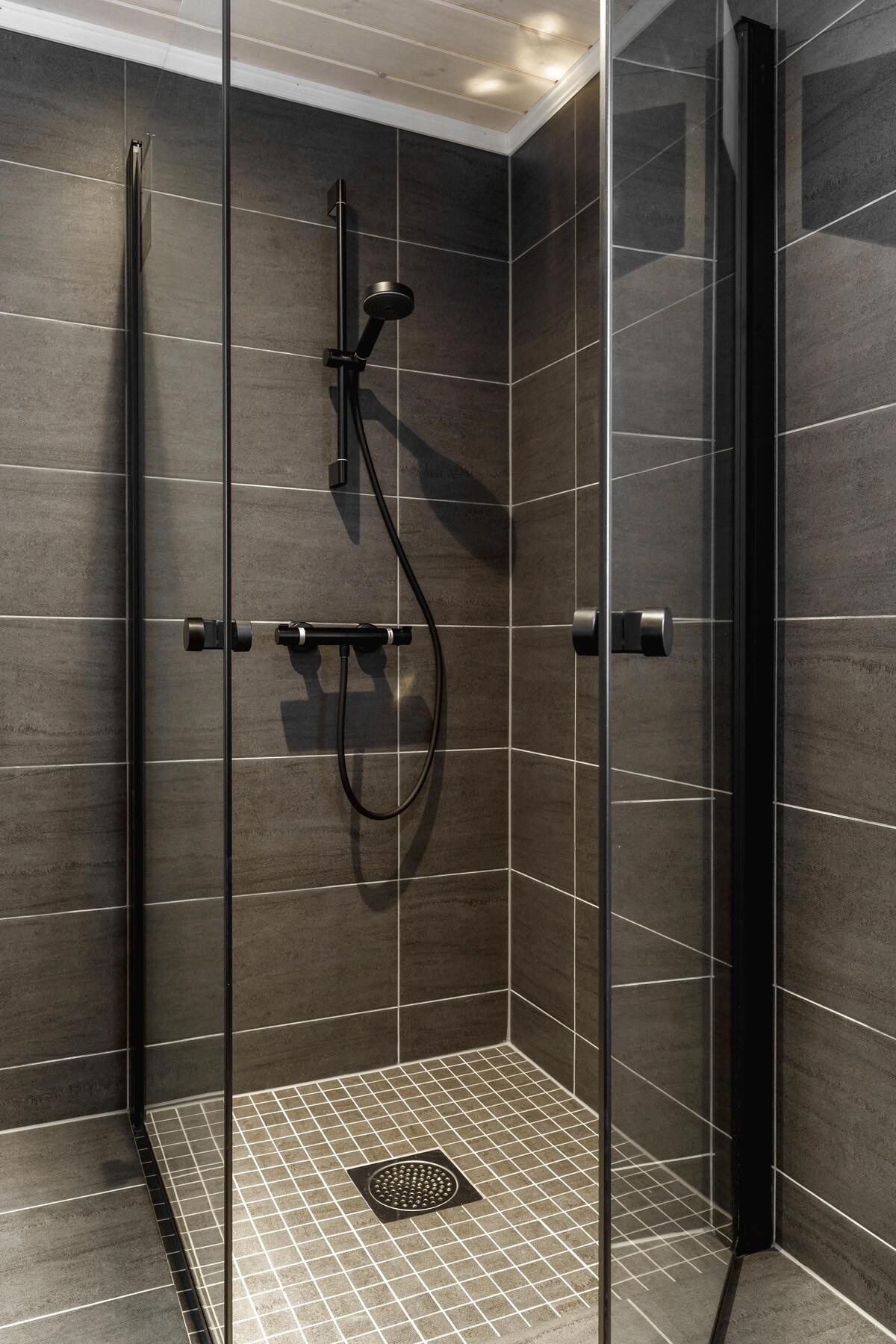 Hovedbad: Dusj med innfellbare dusjdører og sorte detaljer som gir badet et helhetlig uttrykk. (Illustrasjonsfoto fra tilsvarende hytte) Galleribilde
