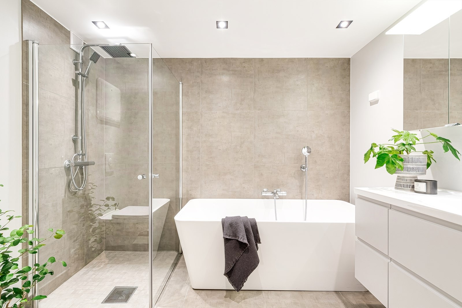 Leilighetens baderom har et lunt, oppvarmet gulv som umiddelbart gir en følelse av velvære. Galleribilde