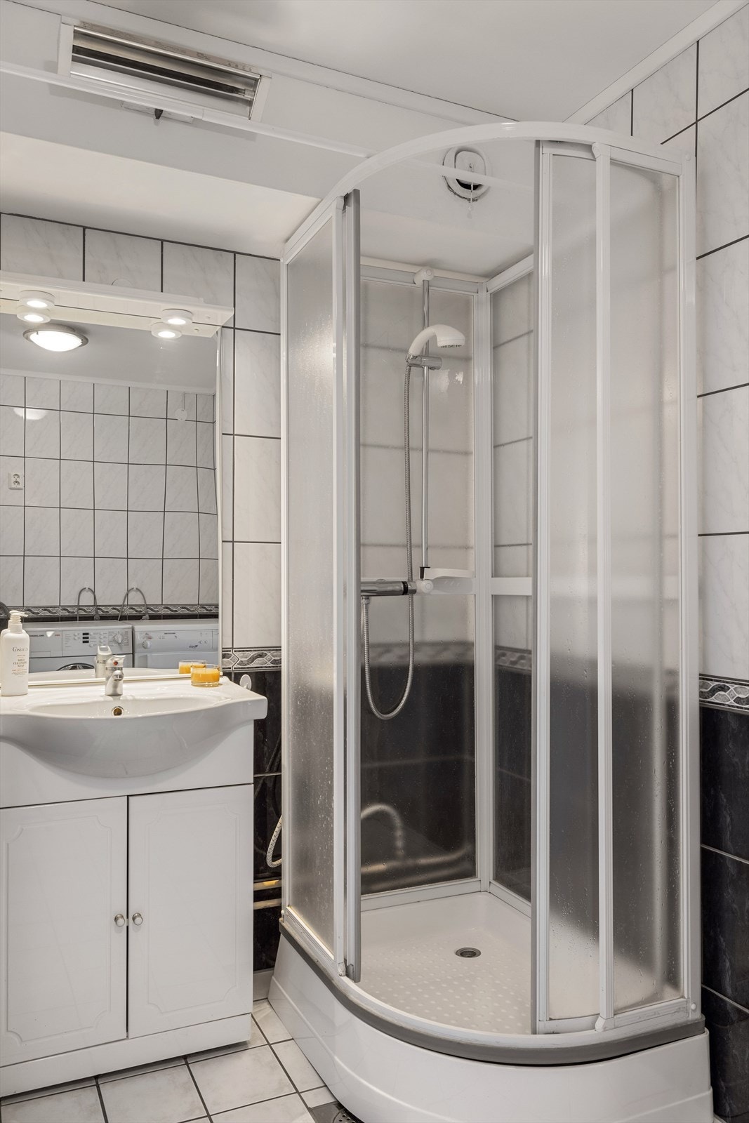 Baderommet er utstyrt med servantskap med ovenpåliggende servant, speil med belysning over, dusjkabinett og stråleovn. Galleribilde