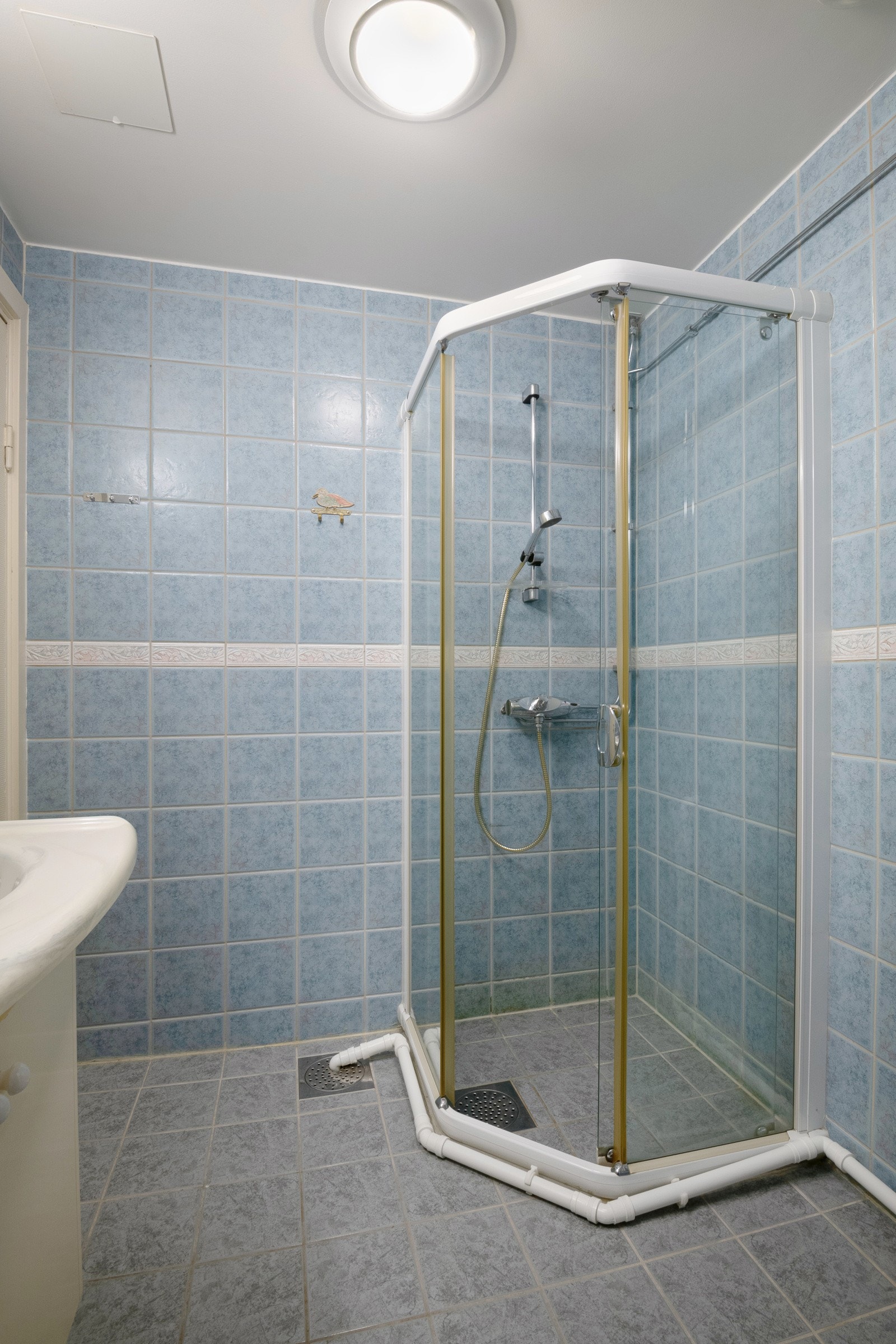 Den praktiske baderomsinnredning sørger for mye oppbevaringsplass. Badet er flislagt med varmekabler i gulv og dusjhjørne med dusjvegger. Galleribilde