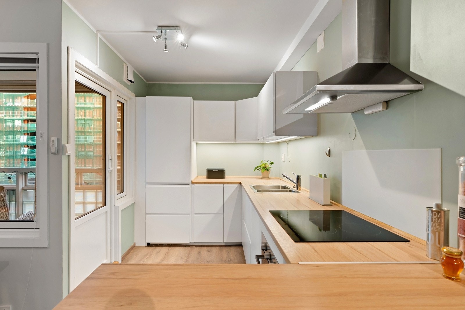 Lekkert og moderne kjøkken som består av hvite fronter og benkeplate i laminat. Galleribilde