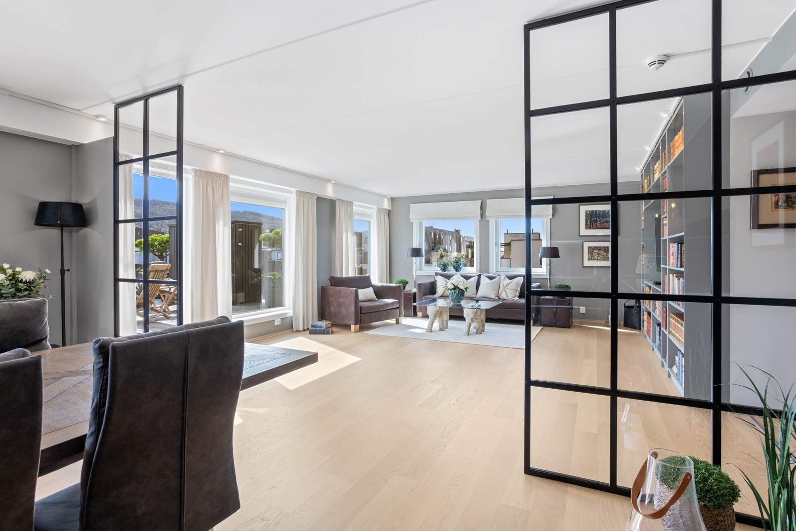 Glassveggene lager et elegant skille mellom kjøkken og stue. Galleribilde