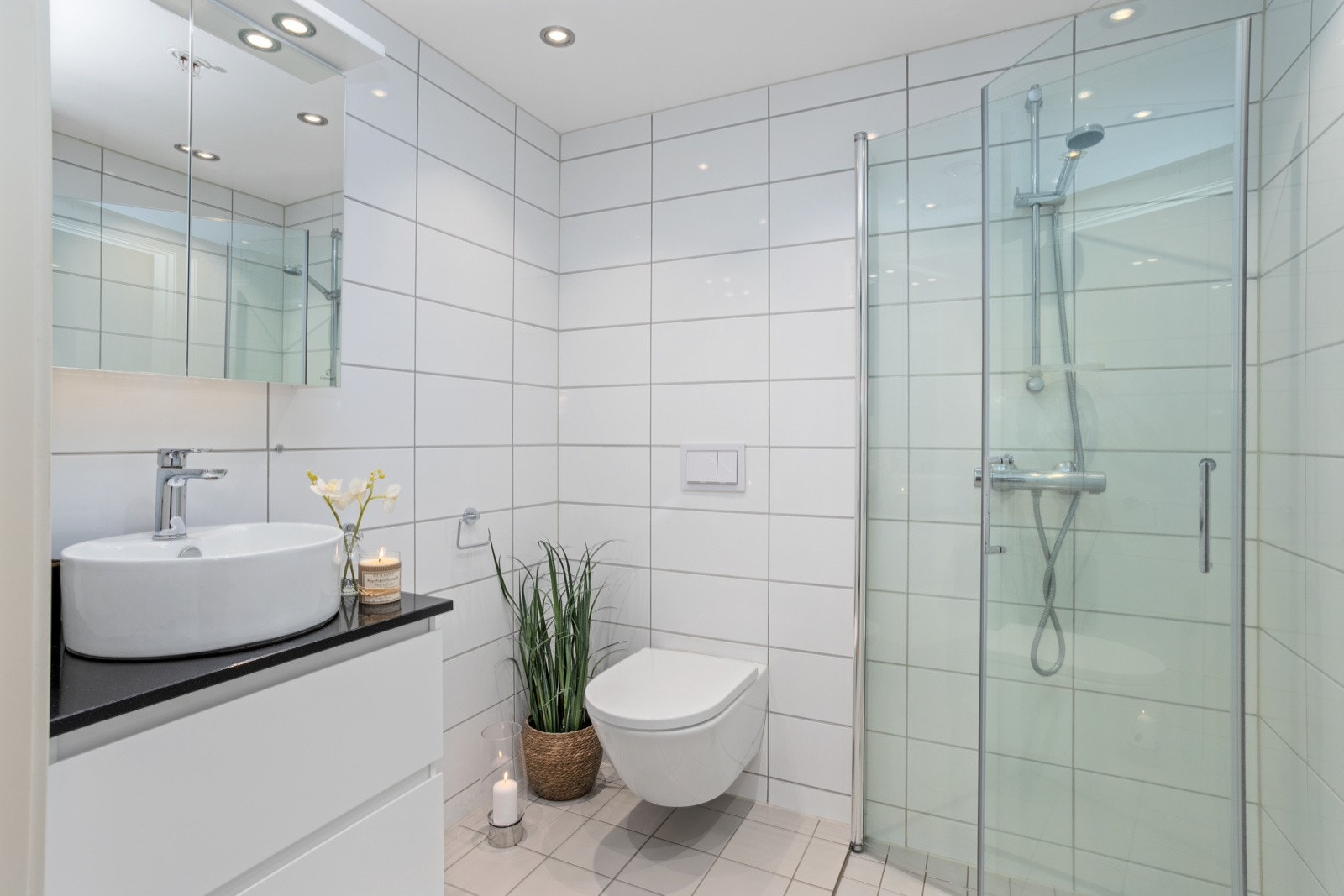 Bad nummer to har dusjhjørne, vegghengt toalett og servant med gode lagringsskuffer. Galleribilde