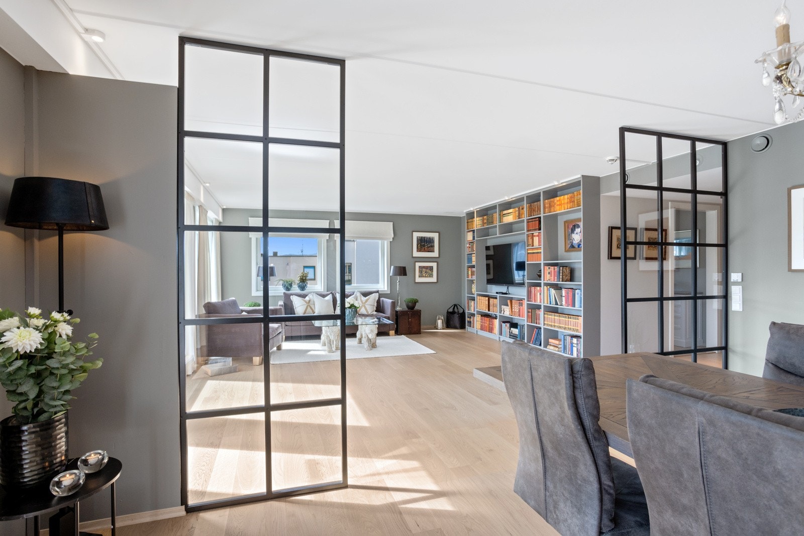 Glasset i veggene lar lyset strømme fritt mellom rommene. Her ser vi fra kjøkkenet inn mot stuen. Galleribilde