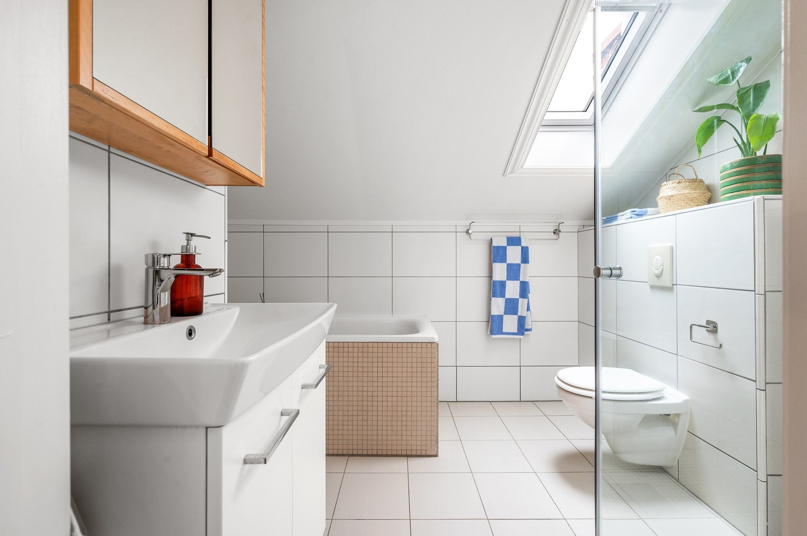 Lyst og pent flislagt bad med varme i gulv for en lun start på dagen. Innredningen består av servant med innredning, speilskap over servant og vegghengt toalett. Galleribilde