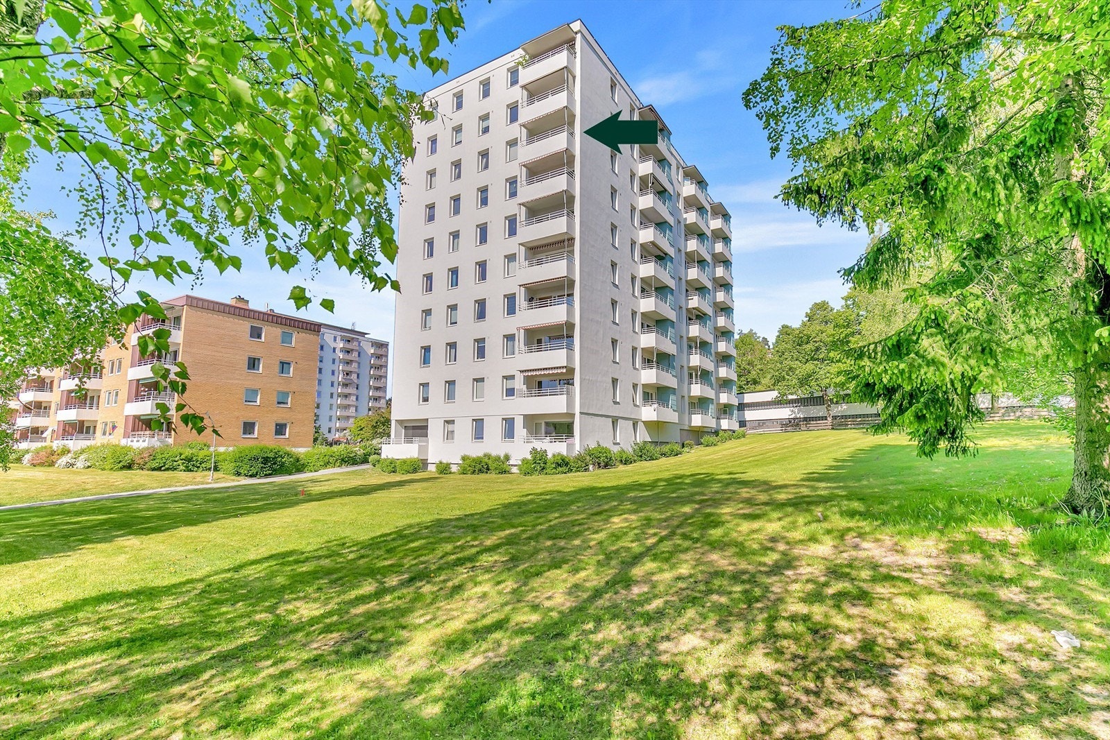 Fasade, sommer - fellesområder har bl.a. sittegrupper, lekeplass og sandkasse. Galleribilde