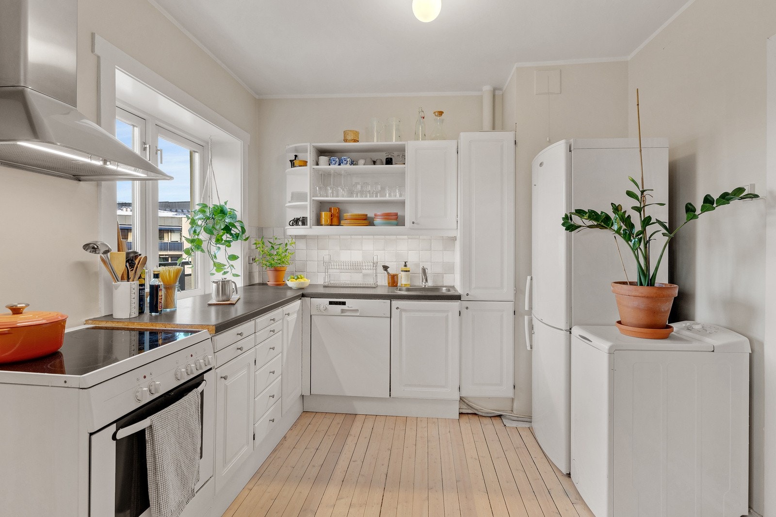 Kjøkkenet inneholder profilerte fronter i hvit utførelse med benkeplate i laminat med nedfelt oppvaskkum. Galleribilde