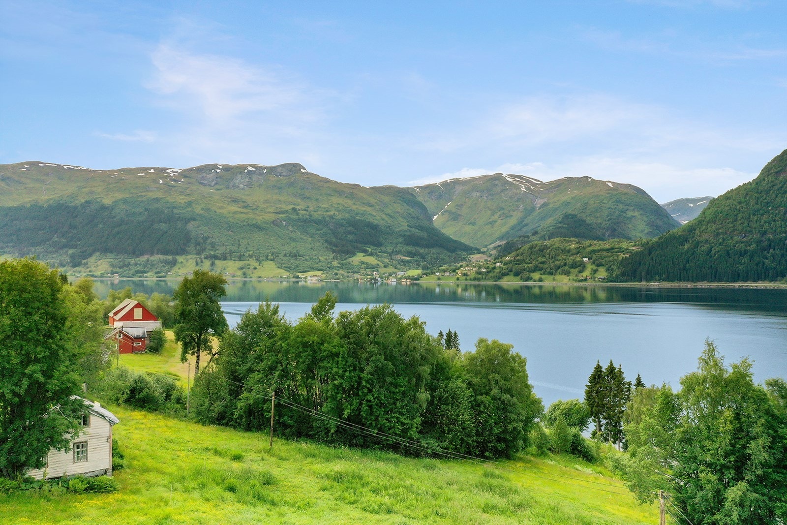 I frå kårbustaden er det flott utsikt til gardstunet og bøen nedanfor. Vidare ser vi utover Jølstravatnet mot Ålhus. Galleribilde