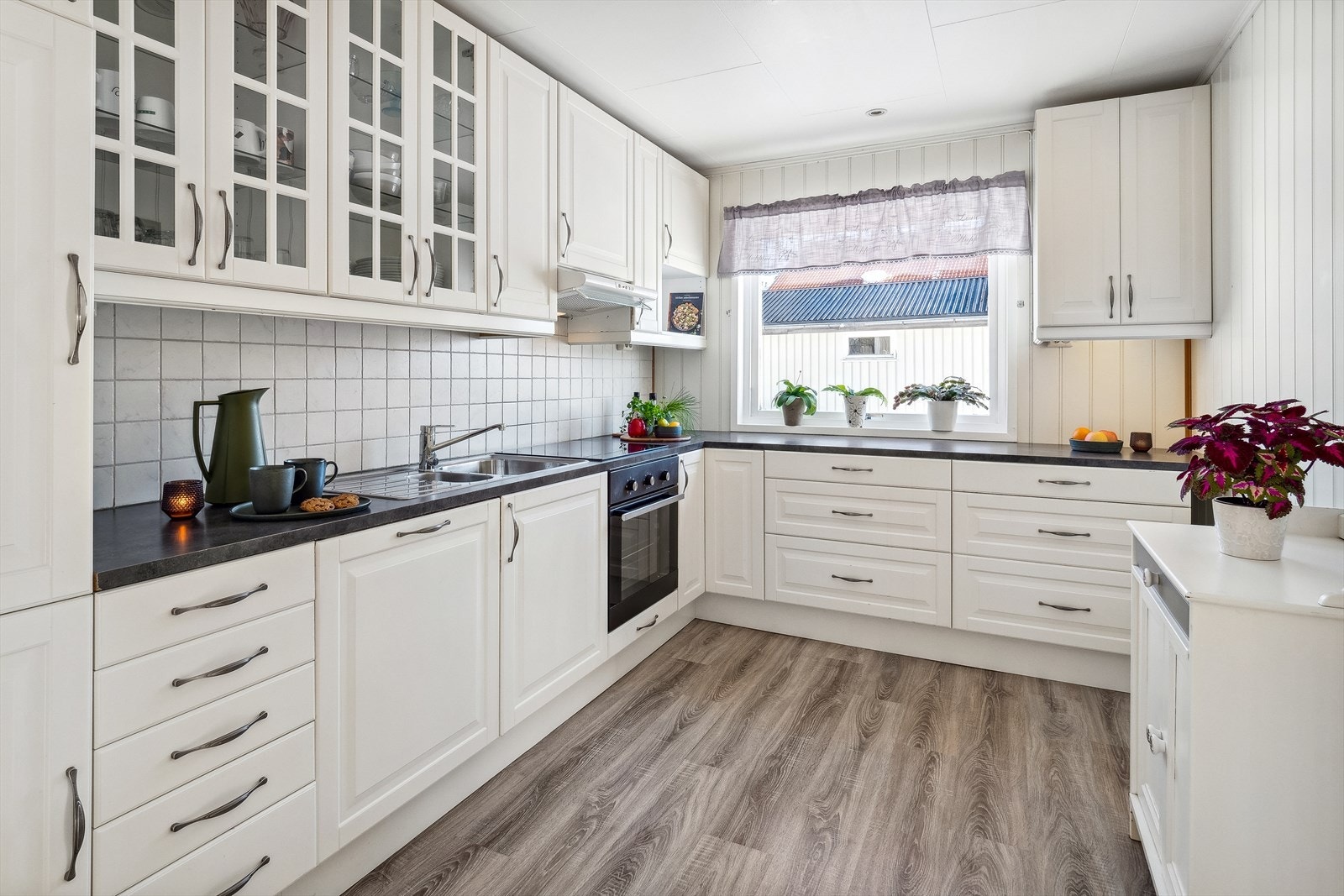 Kjøkkenet har integrerte hvitevarer som kjøl/fryseskap, oppvaskmaskin, platetopp og stekeovn, samt kjøkkenventilator med avtrekk ut. Galleribilde