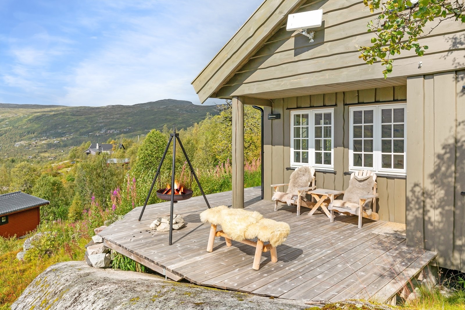Utsikten fra terrassen strekker seg over dalen og fjellene, og gir en følelse av å være i ett med naturen Galleribilde