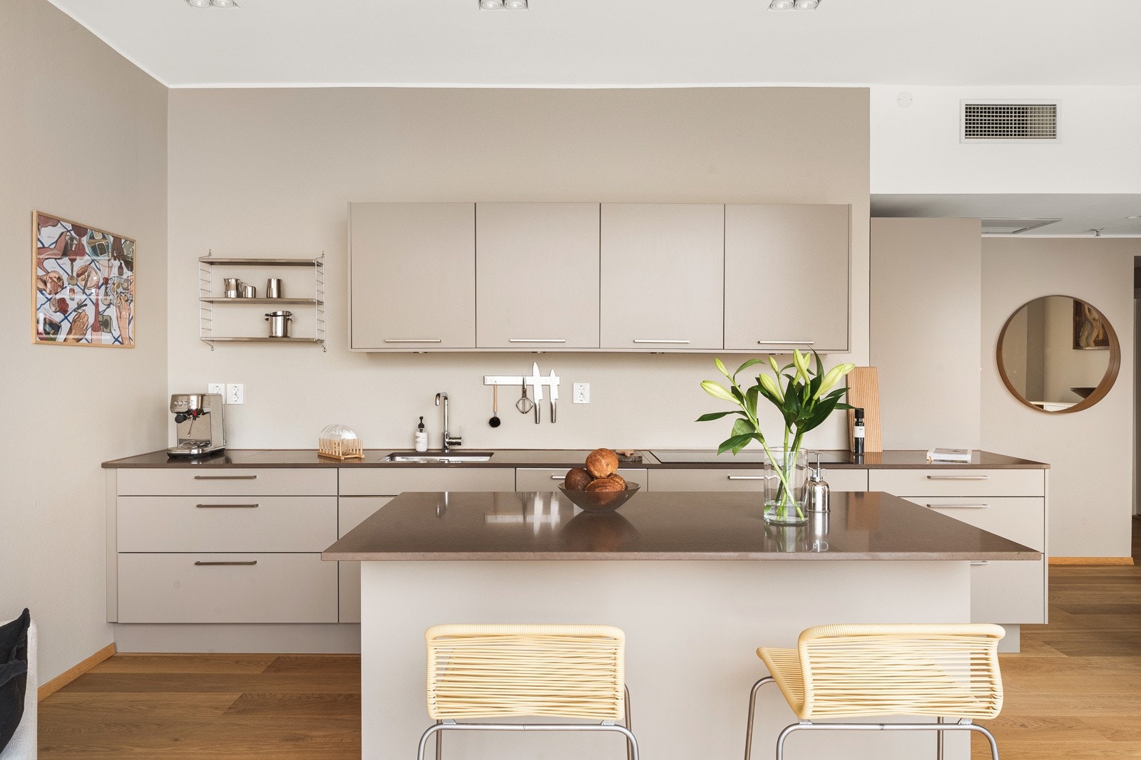En kombinasjon mellom slette fronter og benkeplate i kompositt av typen Silestone med underlimt vask av stål skaper et eksklusivt kjøkken. Galleribilde