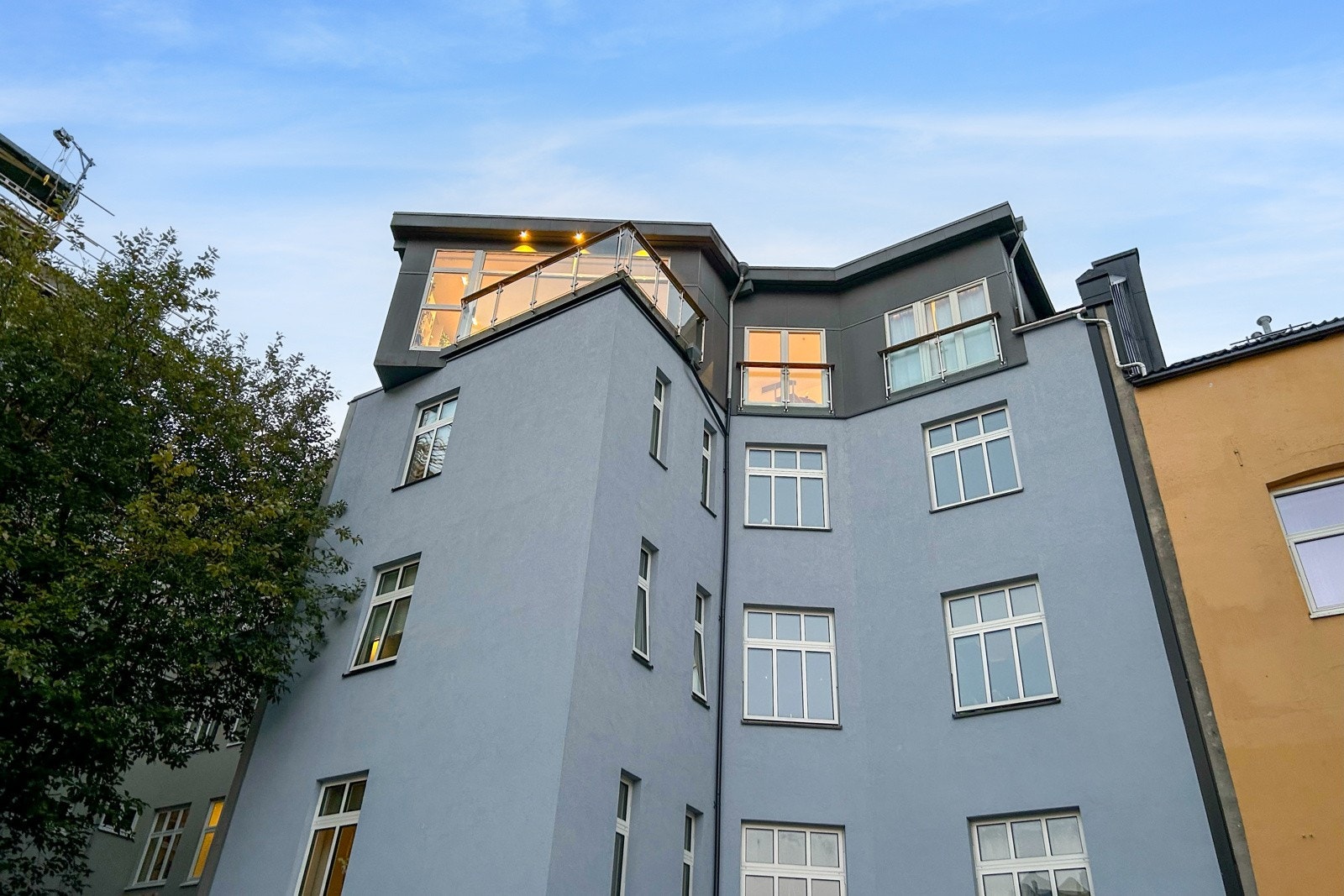 Leiligheten har en spennende arkitektur og er plassert som et moderne tilbygg på taket av en tradisjonell bygård. Galleribilde