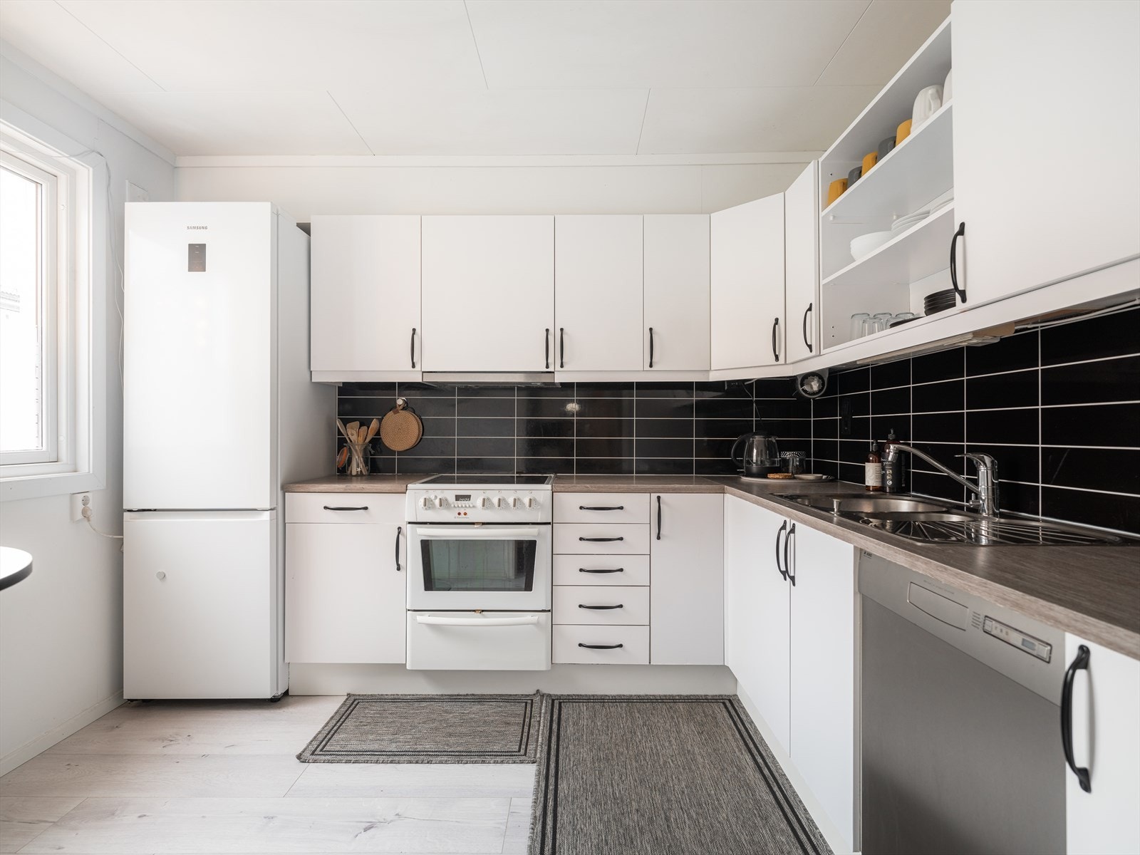 Pent og romslig kjøkken med lys kjøkkeninnredning. Innredningen har godt med skapplass og slette, folierte trefronter. Galleribilde