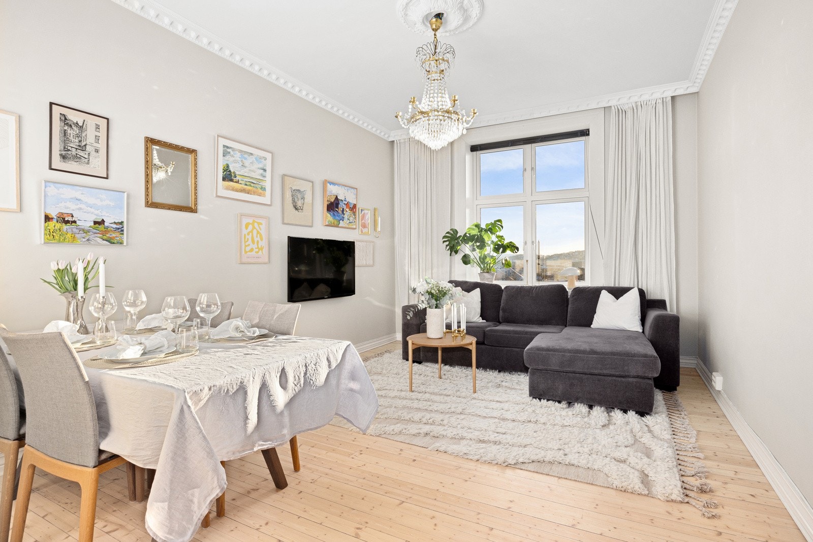 Den staselige stuen smykkes av stukkatur og rosett i himlingen, og har god plass til både tv-lounge og spisebord. Galleribilde