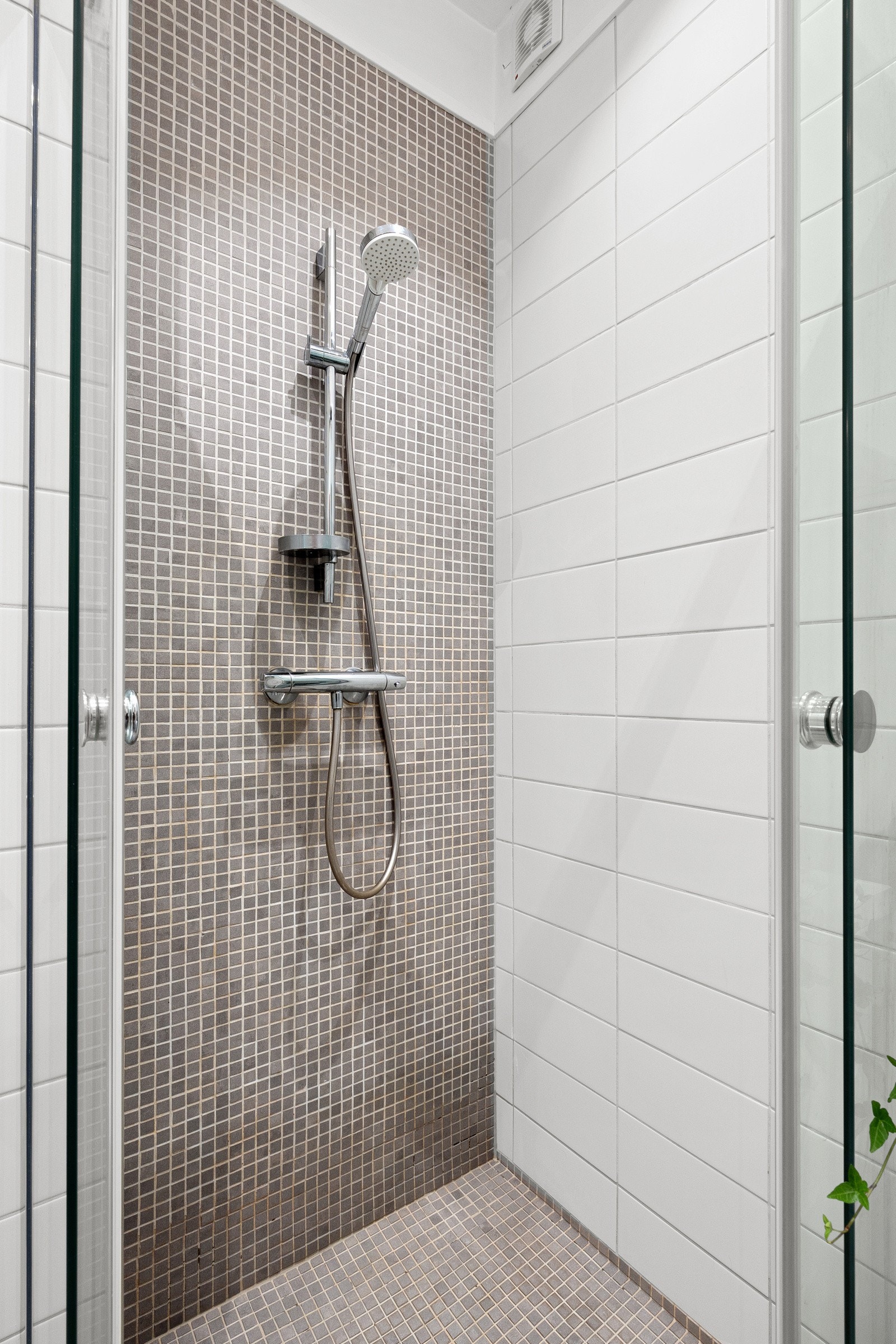 I dusjhjørnet er det lagt mosaikkfliser på gulvet og den ene veggen. Galleribilde