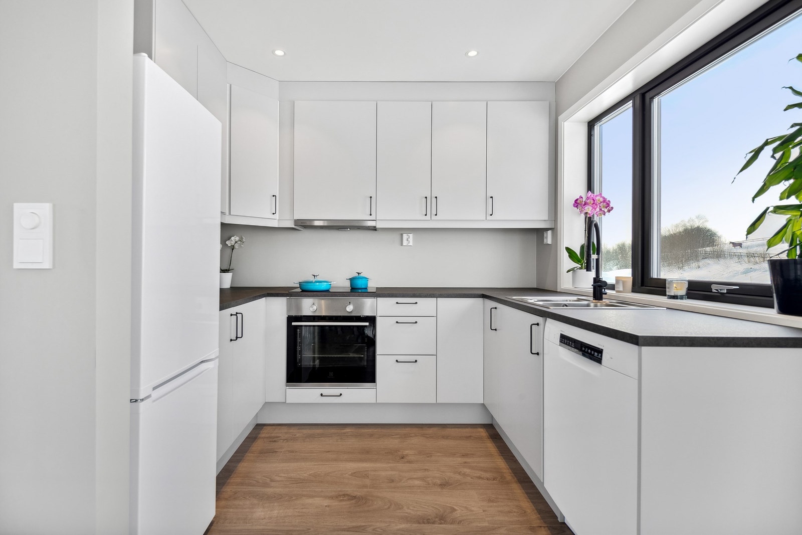 Lyst kjøkken med gode arbeidsflater og takhøye skap for maksimal utnytting av plassen. Galleribilde