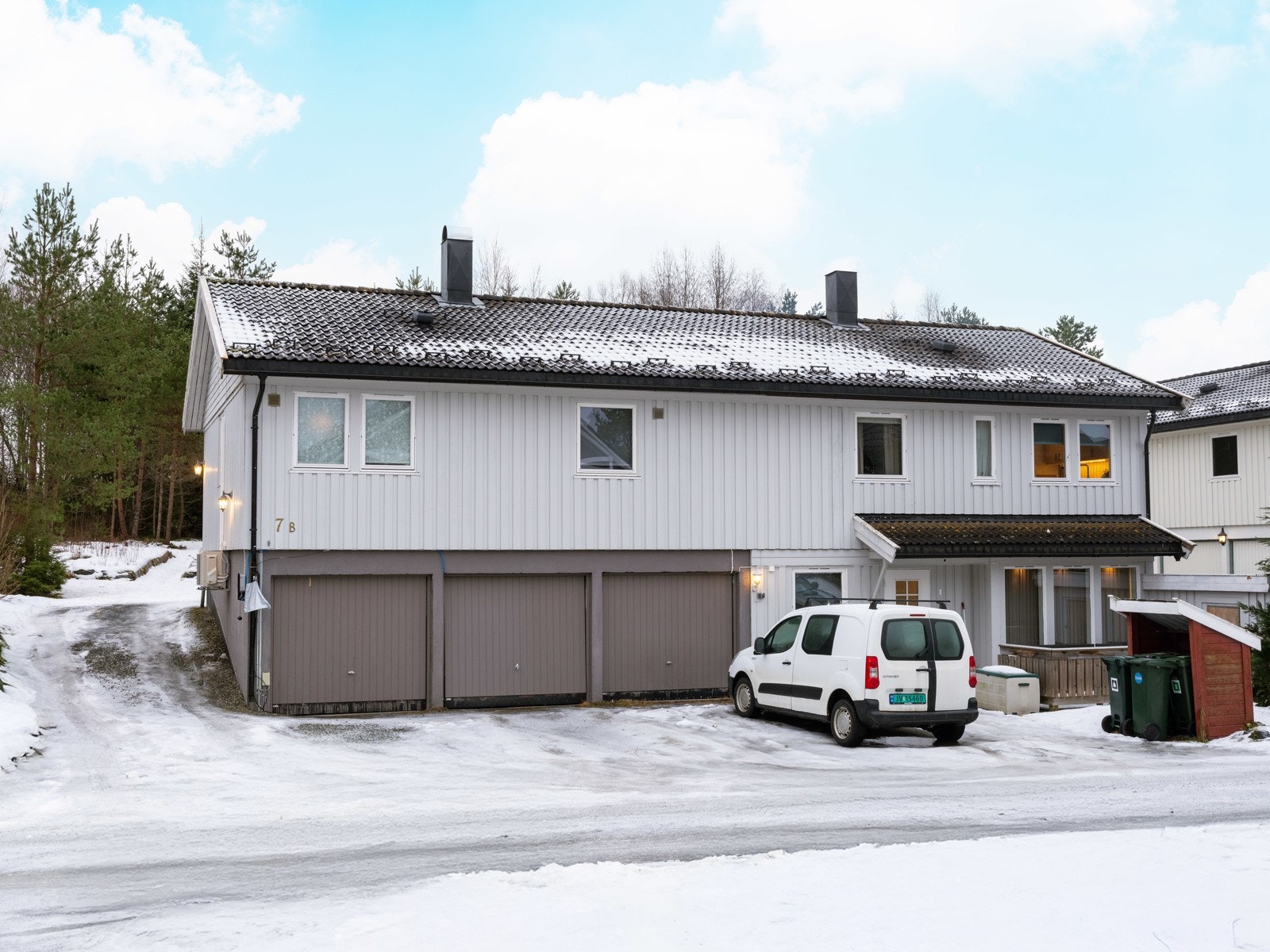 Leiligheten disponerer egen garasje i sokkel og biloppstillingsplass foran garasjen. Sameiet har felles gjesteparkering på grusveien til venstre for huset. Galleribilde