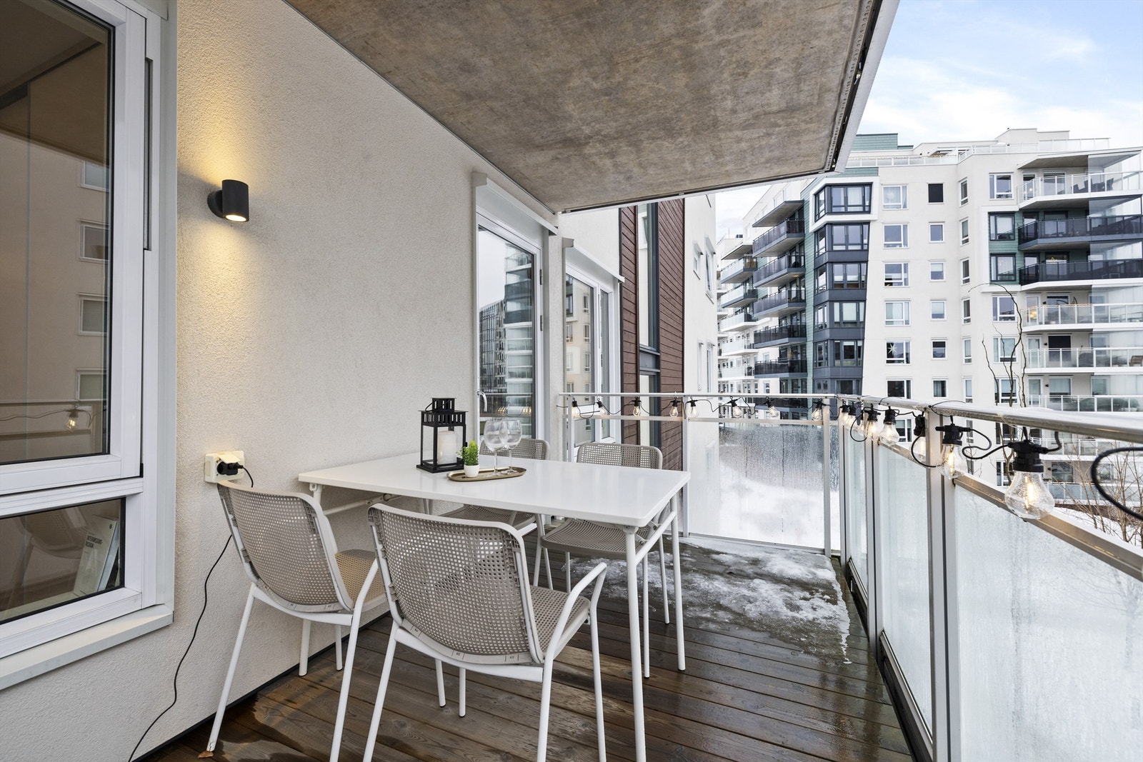 Plass til blant annet utemøbler og grill. Gulvflate belagt med terrassebord. Belysning og stikkontakt på vegg. Rekkverk av glass og metall. Galleribilde