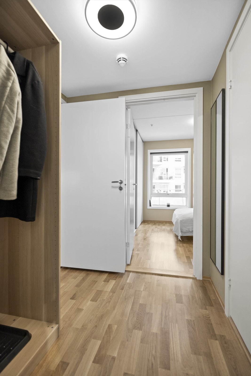 Innbydende entré med adkomst til alle rom i leiligheten. Plass til oppheng av tøy og oppbevaring av sko. Galleribilde