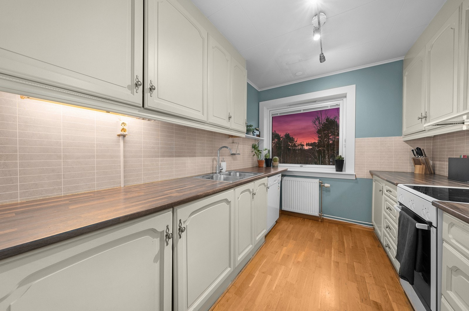 Kjøkkenet er videre utstyrt med rustfri vask med skyllekum, samt en kjøkkenventilator med kullfilter. Kjøleskap og fryser er integrert, og det er en nisje for både komfyr og oppvaskmaskin. Over benkeskapene er det våtromsplater, og det er belysning under. Galleribilde