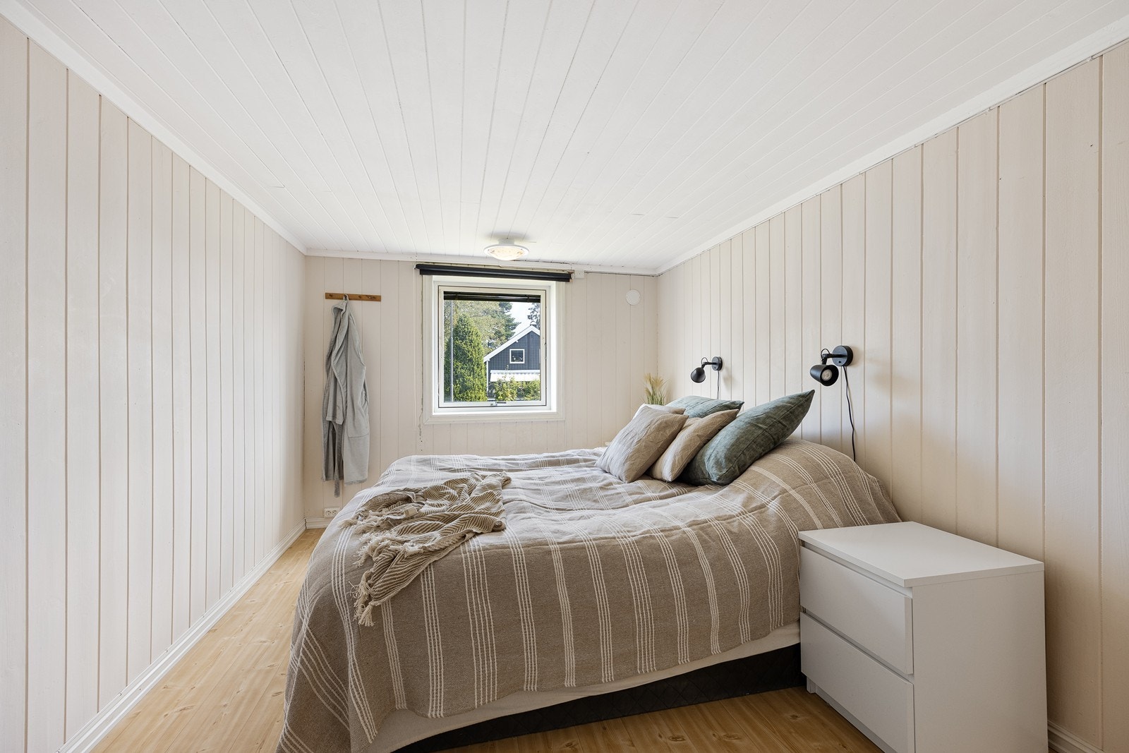 Det er også plass til dobbeltseng på det andre rommet, som ellers har samme farge på veggpanel, gulv i heltre og lagringsmuligheter i kott. Galleribilde