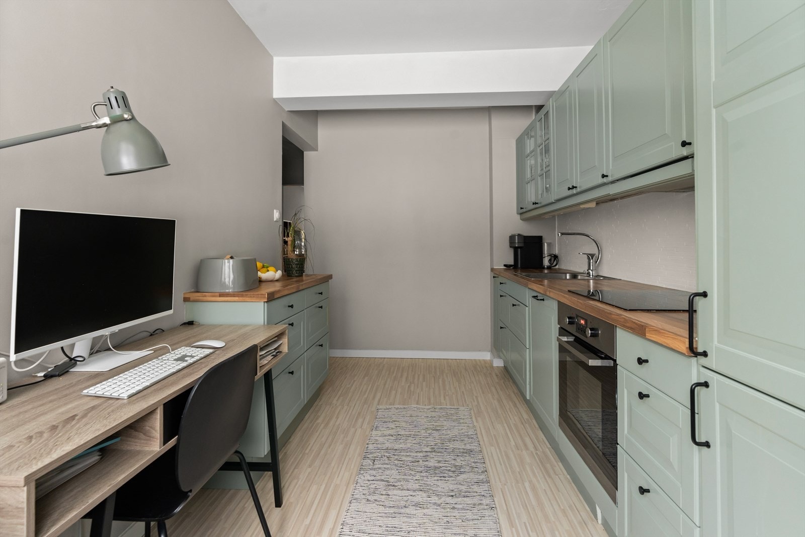 Det er satt inn belysning under overskapene og fliser på veggen over benkeplaten. Galleribilde