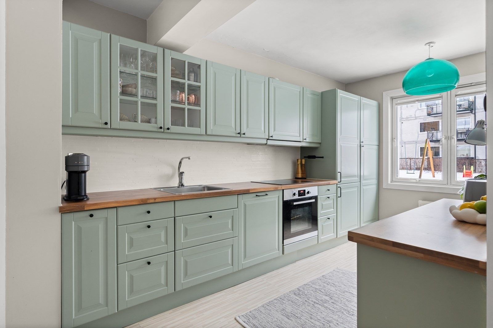 Separat kjøkken med mye benk- og skapplass! Innredningen er fra IKEA, og har malte profilerte fronter samt laminat benkeplate med nedfelt kum i rustfritt stål. Galleribilde