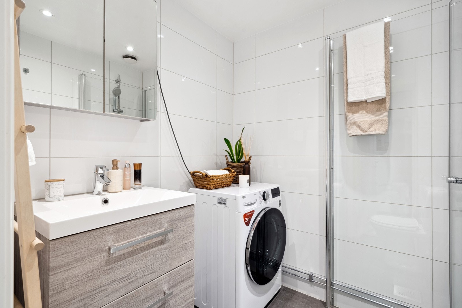 Delikat og lyst flislagt bad med opplegg til vaskemaskin. Galleribilde